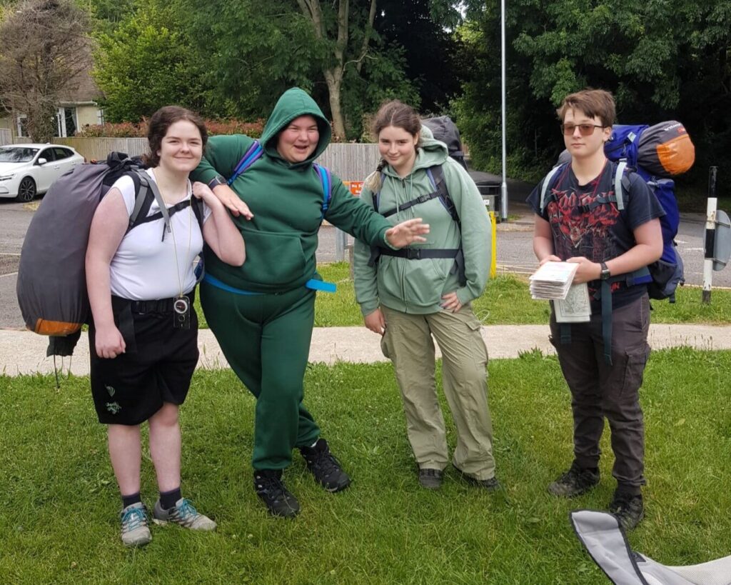 4 students posing for a photograph by the roadside