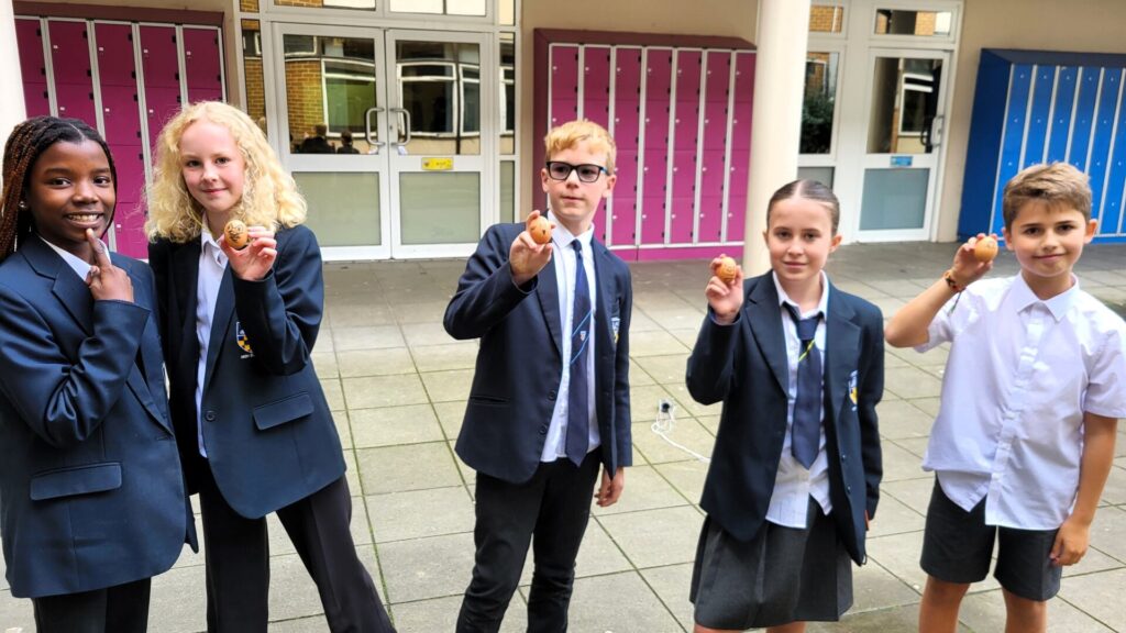 Students holding up their eggs without cracks.