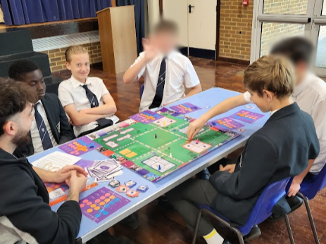 Students sitting around a table playing the Uni Game.