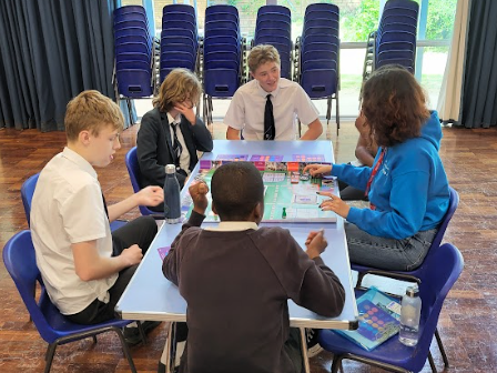 Students sitting around a table playing the Uni Game.
