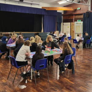 Wide shot of the School Hall with tables of Students and representatives from Brighton Uni playing the Uni Game.