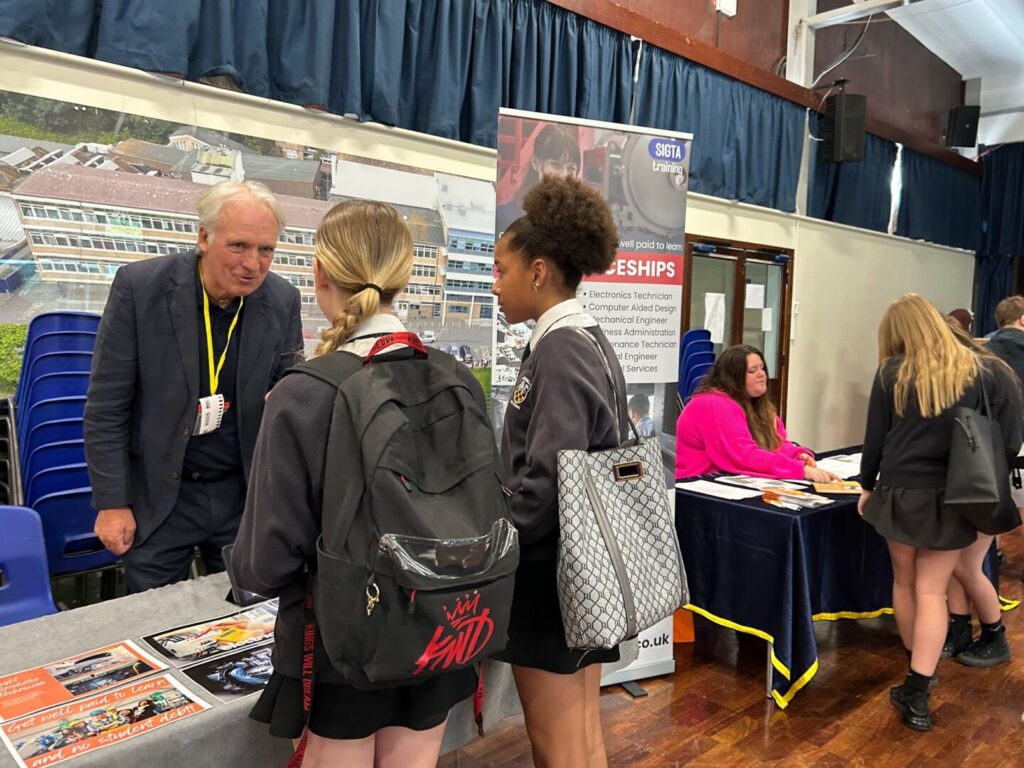 Students at Longhill's Career's Fair 2025, speaking to representatives of SIGTA training.