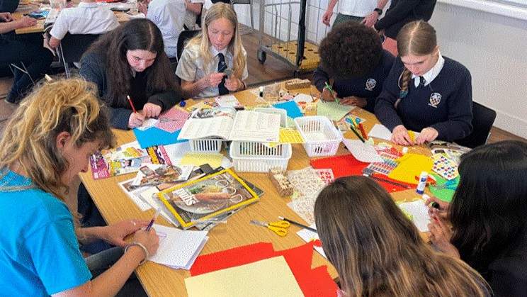 Students at the University of Brighton, participating in a exercise around a table.