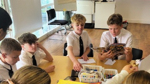 Students at the University of Brighton, participating in a exercise around a table.
