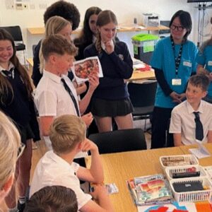 Students at the University of Brighton, participating in a exercise around a table.