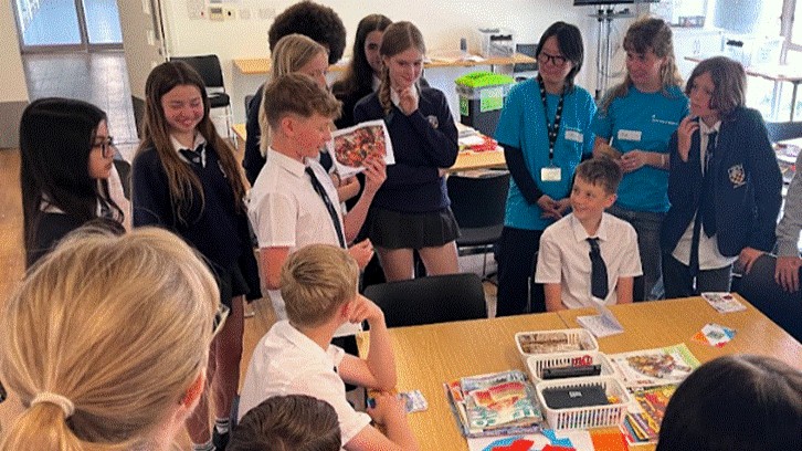 Students at the University of Brighton, participating in a exercise around a table.