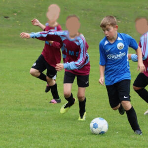 Student driving past opponents on the pitch.