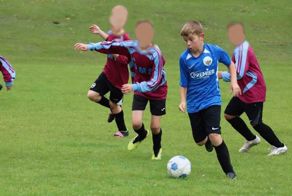 Student driving past opponents on the pitch.