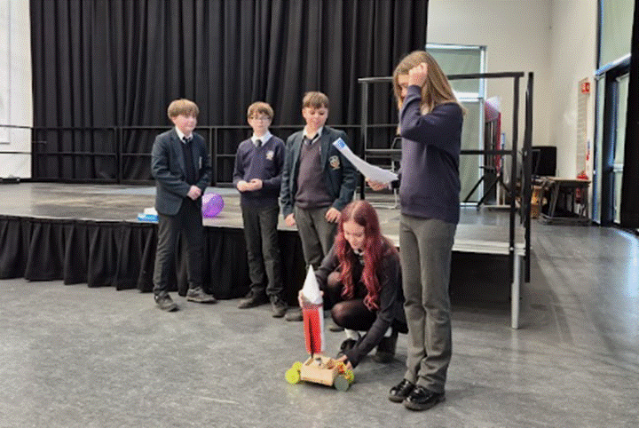 Students are demonstrating their mechanical device.