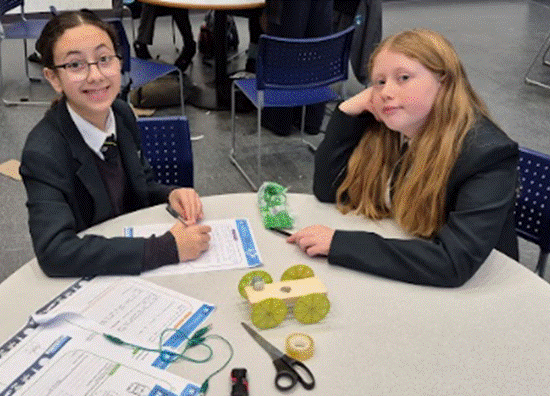 Students at a table posing for a photograph