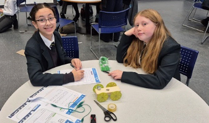 Students at a table posing for a photograph