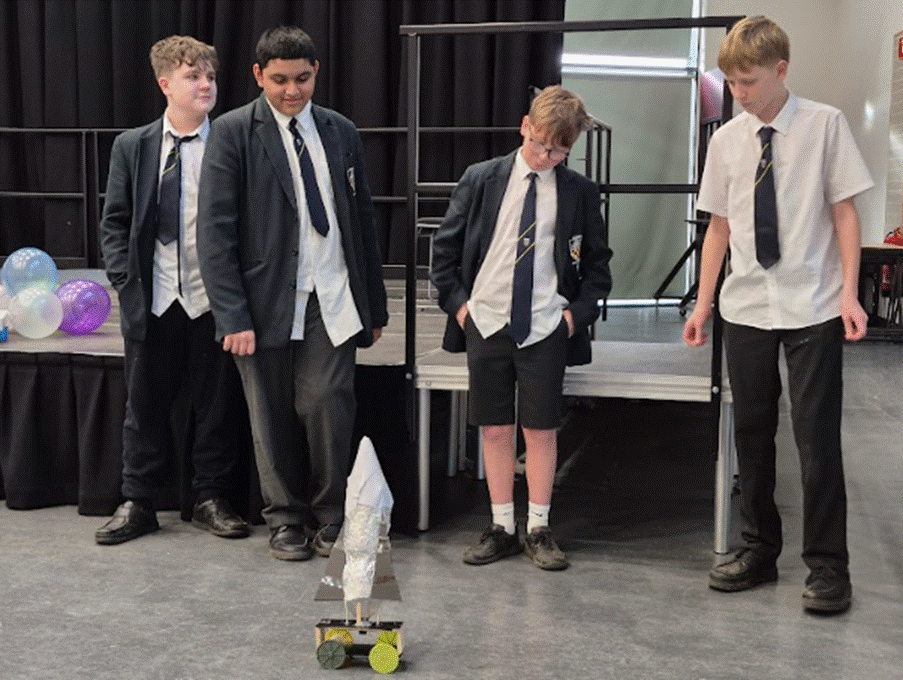 Students around their mechanical device