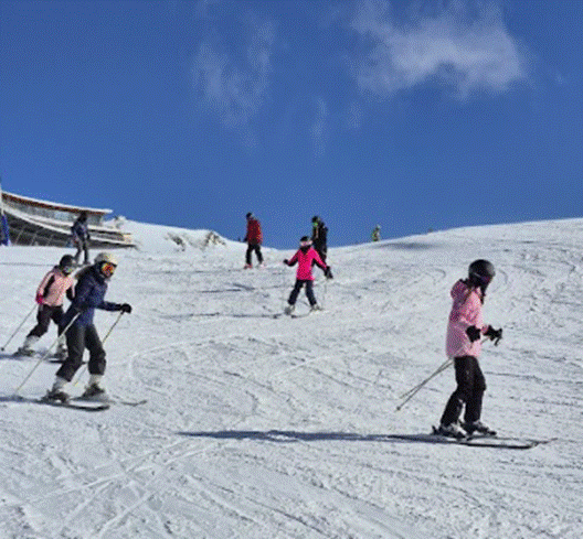 Students skiing down slope
