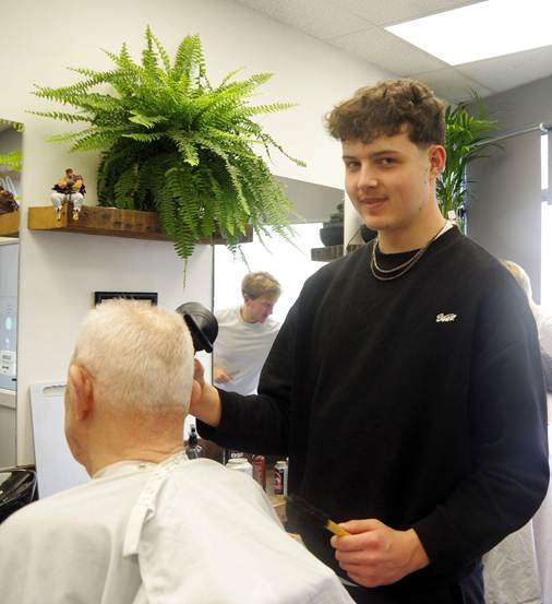 Student cutting hair of a customer