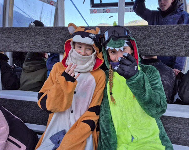 Students sitting at the bottom of a slope posing for photograph