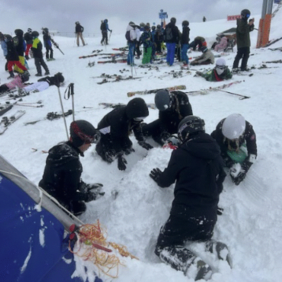 Group of students burying another student under the snow.