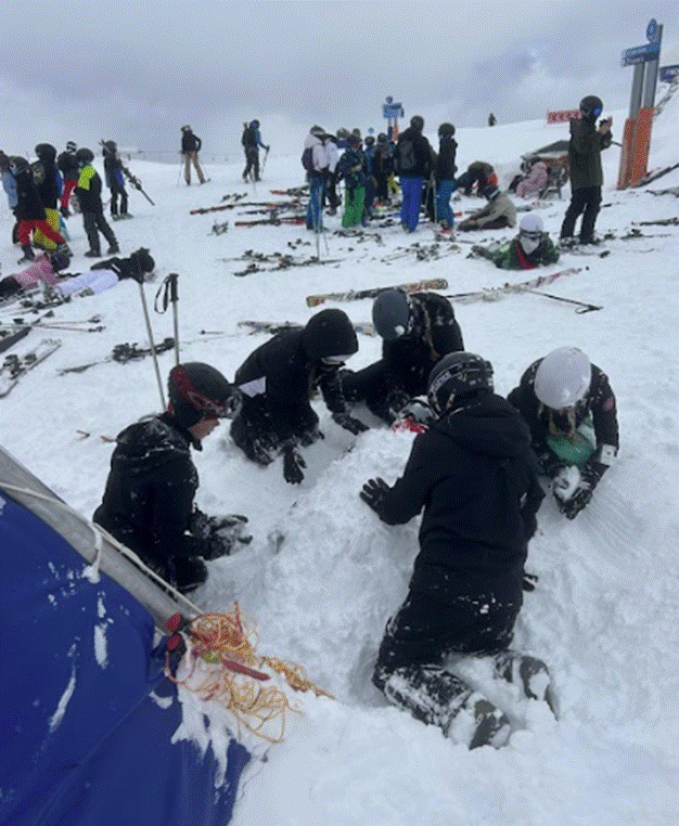Group of students burying another student under the snow.