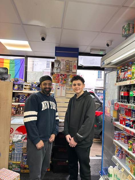 Student posing with owner in store.