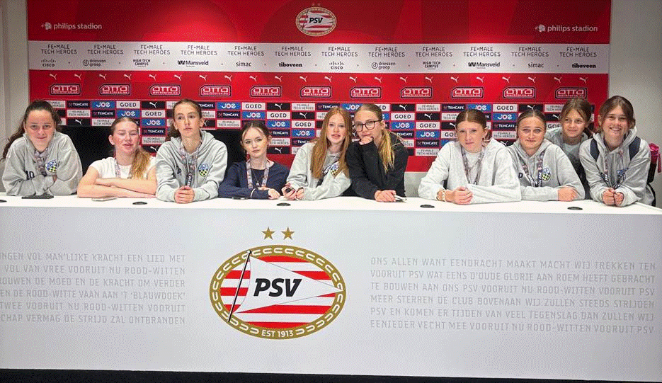 Students posing for a photo in the press room.