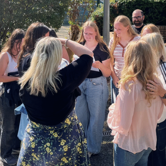 Students gathered together in a group discussing their results